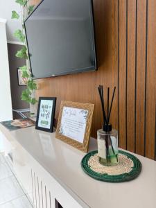 a white counter with a tv on a wall at Apto Serras Gerais 2 in Dianópolis