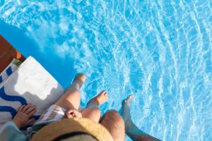two people laying on the side of a swimming pool at Nautilus Beach Resort by Charlesworth in Coffs Harbour