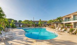 a swimming pool with lounge chairs and a resort at Tanoa Waterfront Hotel in Lautoka