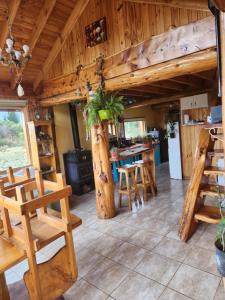 eine Küche mit Holzwänden, Tischen und Stühlen in der Unterkunft Los Trevelinos in Trevelín