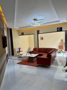 a living room with a brown couch and a table at Résidence MBK Suite in Ziguinchor