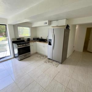 a kitchen with a stainless steel refrigerator and a stove at Hector residence in Saint Johnʼs