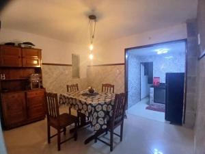 a dining room with a table and chairs and a kitchen at aconchego pe na areia in Ilhéus