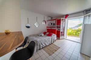a bedroom with a bed and a table and chairs at Beau studio au coeur du Gosier in Le Gosier