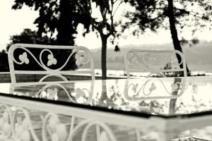zwei weiße Stühle an einem Glastisch in der Unterkunft Villa Irini in Porto Heli