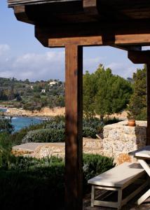 pérgola de madera con banco y río en Villa Irini, en Porto Heli