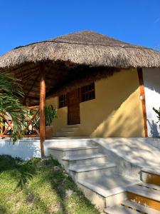 a building with a straw roof and stairs in front at Hotel Aldea Cruzo'ob in Felipe Carrillo Puerto