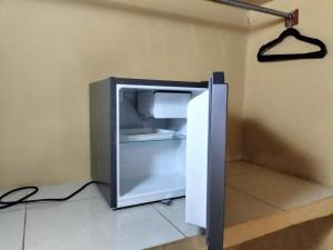 an empty refrigerator with its door open in a room at Hotel Aldea Cruzo'ob in Felipe Carrillo Puerto