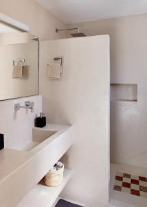 a white bathroom with a sink and a mirror at Villa Irini in Porto Heli