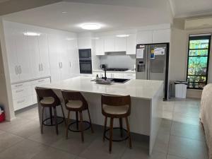 a kitchen with a counter and two bar stools at Luxury Newport canal king suite home in Redcliffe