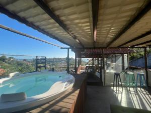 a hot tub on the balcony of a house at Palmares, Casa Rustica Suites Buzios in Búzios
