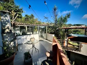 a balcony of a house with a table on it at Palmares, Casa Rustica Suites Buzios in Búzios
