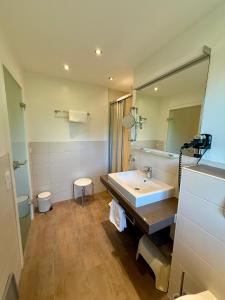 a bathroom with a sink and a large mirror at Hotel Steffl Garni inkl Chiemgau Karte in Ruhpolding +78 photos