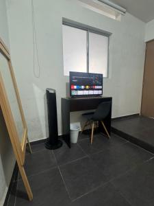 a room with a desk with a computer and a window at suite doble ejecutiva providencia in Guadalajara