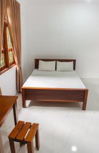 a bedroom with a bed and a bench and a window at Heaven inn Hotel, Digana in Digana