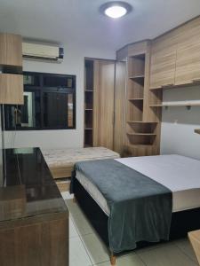 a bedroom with a bed and a desk in a room at 2-bedroom apartment in Ubá