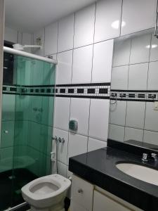 a bathroom with a toilet and a glass shower at 2-bedroom apartment in Ubá