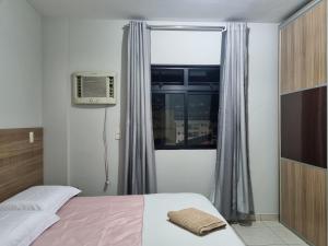 a bedroom with a bed and a window at 2-bedroom apartment in Ubá