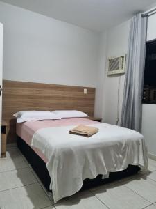 a bedroom with a bed with a towel on it at 2-bedroom apartment in Ubá +7 photos