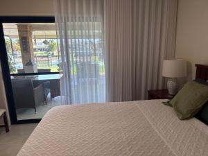a bedroom with a bed and a view of a table at Luxury Newport canal king suite home in Redcliffe +16 photos