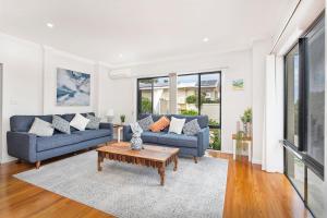 a living room with two blue couches and a coffee table at Echo Waves in Kiama
