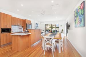 a kitchen and dining room with a table and chairs at Echo Waves in Kiama