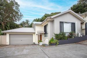 a white house with a garage at Echo Waves in Kiama