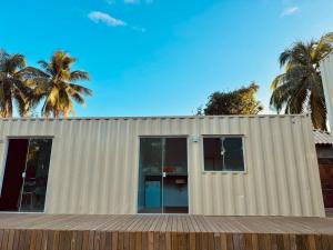 a white building with palm trees in the background at Villa Davi, A 100m DA PRAIA! in Barra Grande
