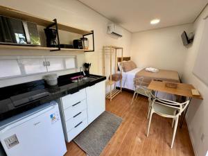 a small kitchen with a table and a bed at Villa Davi, A 100m DA PRAIA! in Barra Grande