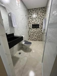 a white bathroom with a toilet and a sink at chacara por do sol in Piranhas