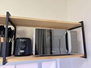 a microwave oven sitting on top of a shelf at Villa Davi, A 100m DA PRAIA! in Barra Grande +4 photos