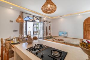 a kitchen and living room with a table and a stove at Chic 2BR Private Pool Villa in Canggu in Dalung