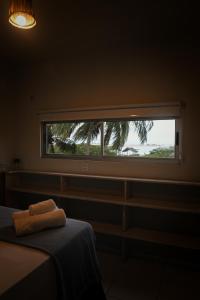 a bedroom with a window with a towel on a bed at CasaMar Guriú in Guriú +10 photos