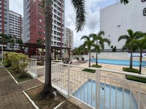 a resort with a pool and palm trees and buildings at Apartment in Ponta Negra in Manaus