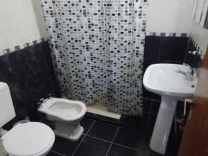 a bathroom with a toilet and a sink at Hotel Graciela in Villa Carlos Paz