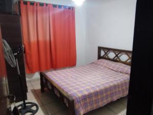 a bedroom with a bed and a red curtain at Hotel Graciela in Villa Carlos Paz