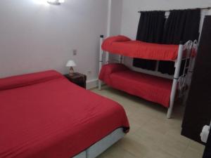 a bedroom with a red bed and a red chair at Hotel Graciela in Villa Carlos Paz