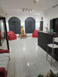 a living room with red chairs and a counter at Hotel Graciela in Villa Carlos Paz