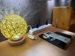 a lamp sitting on a table next to a remote control at fishing inn beach house in Amami