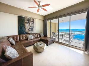 a living room with a couch and a ceiling fan at Beachfront Condo with Stunning Views Tranquil Stay in Puerto Peñasco