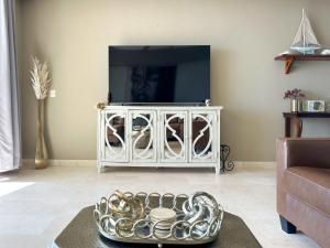a living room with a tv and a silver bowl at Beachfront Condo with Stunning Views Tranquil Stay in Puerto Peñasco