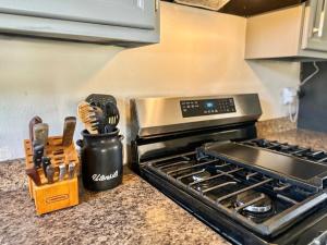 a kitchen counter with a stove and a knife block at Lux Modern 3BR King Bed Smart TV PetFriendly in Killeen +23 photos