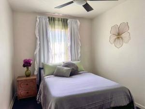 a bedroom with a bed with a ceiling fan and a window at Lux Modern 3BR King Bed Smart TV PetFriendly in Killeen