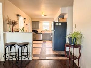 a kitchen with a refrigerator and two bar stools at Lux Modern 3BR King Bed Smart TV PetFriendly in Killeen