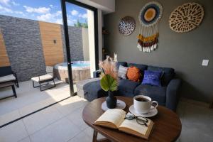 a living room with a couch and a table with a book at Depto nuevo de lujo en PB|Terraza con jacuzzi |Gym in Guadalajara