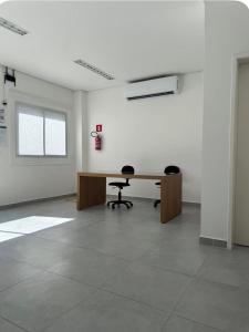an empty room with a desk and two chairs at apartamento ana julia modesto in Juazeiro do Norte