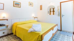a bedroom with a yellow bed with a yellow blanket at Hotel Canasta in Misano Adriatico