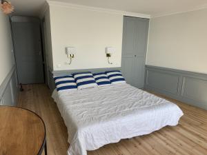 a bedroom with a bed with blue and white pillows at Mado by Scoop in Le Crotoy