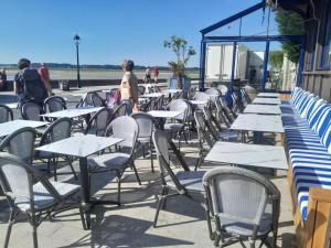 a row of tables and chairs sitting outside of a building at Mado by Scoop in Le Crotoy