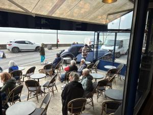 a group of people sitting at tables in a restaurant at Mado by Scoop in Le Crotoy